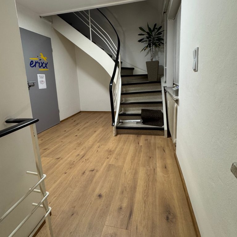 Modernisiertes Treppenhaus bei erixx in Bad Harzburg mit neuem Bodenbelag für einen gepflegten, sicheren Eingangsbereich.