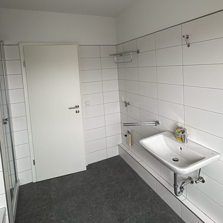 Komplett renoviertes Bad mit neuem Waschbecken und weißen Fliesen in Bad Harzburg, modernisiert von BKL Dienstleistungen.